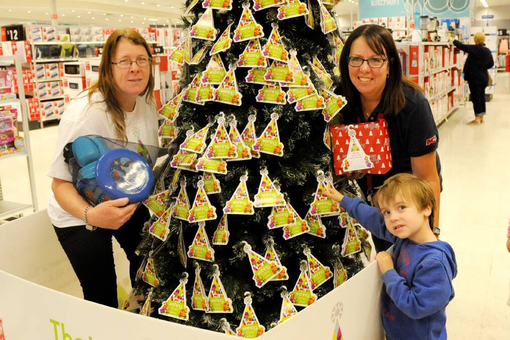 GIFTS: Horsham Kmart team members Kylie Smith and Shirlene Simmons with Horsham's Koby Clarke, 3, at the launch of the wishing tree appeal. Pictures: SAMANTHA CAMARRI