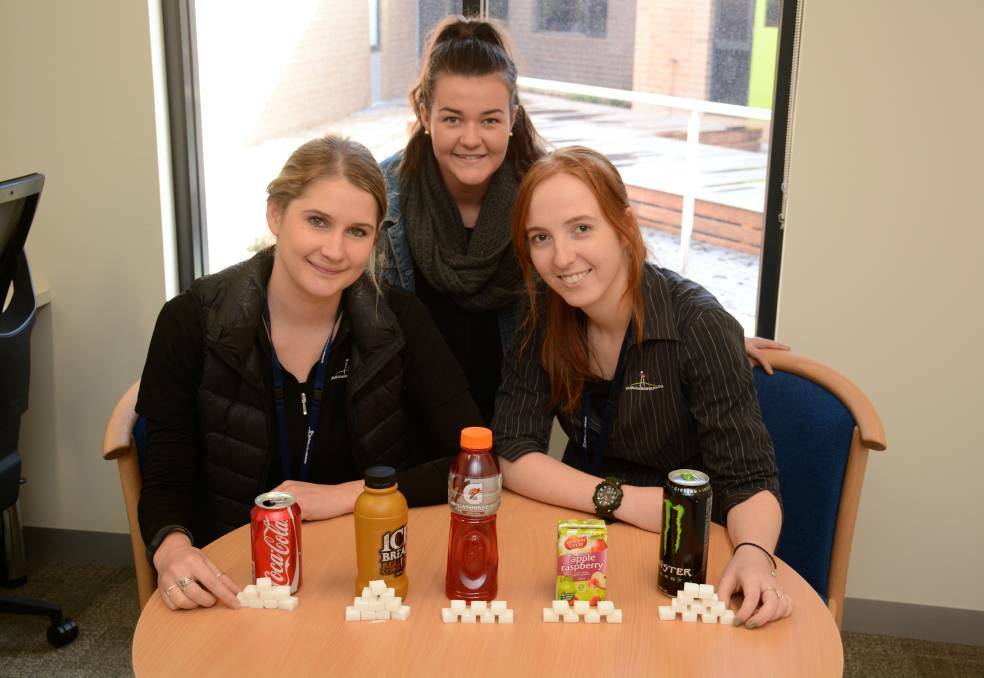 Rural Northwest Health dietitian Ashley Webb, work experience student Lauren Bond and exercise physiologist Liz Maxwell show how much sugar is in popular drinks. Pictures: CONTRIBUTED