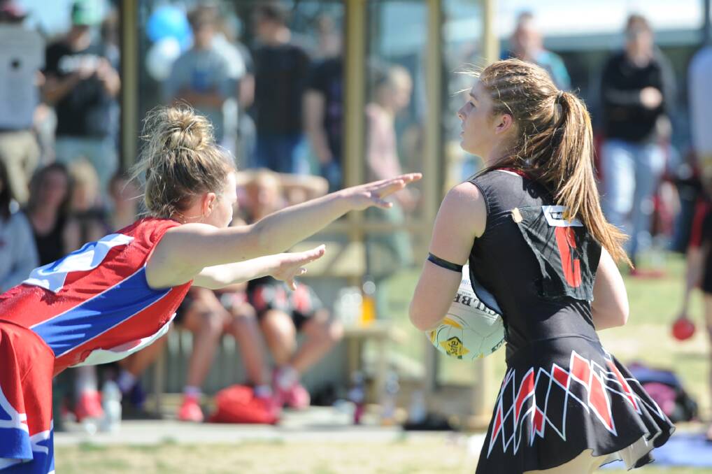 STRETCH: Kalkee's Aily McAuliffe reaches out as she defends Noradjuha-Quantong's Keziah Freeman in the 2014 grand final. Picture: SAMANTHA CAMARRI