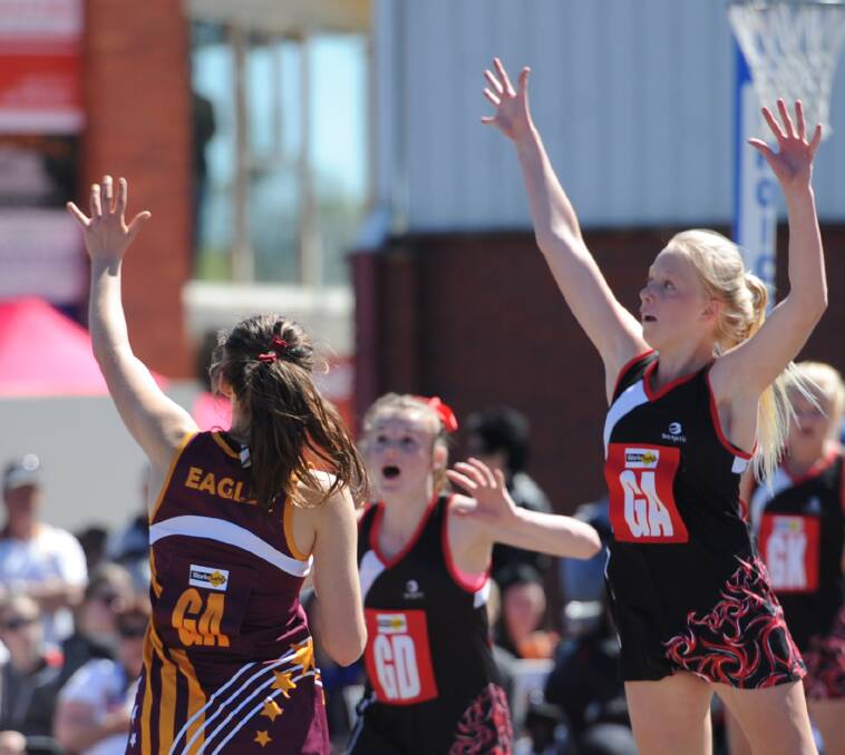 ARMS UP: Summer Schultz is defended by Katie Buwalda in the 17 and under grand final in 2014.