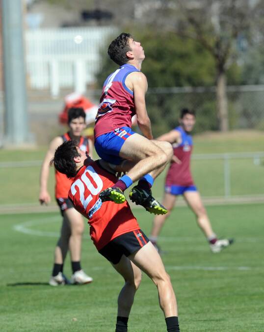 SOARING: Horsham's Ryan Kemp flies over Stawell's Sam Williams in the under-17 grand final in 2014. Pictures: PAUL CARRACHER