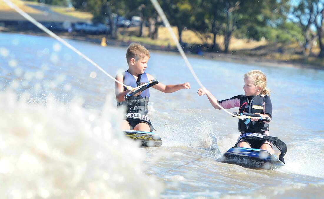 FIST BUMP: Jye Dolan and Ellita Scollary have fun on the water at Green Lake. Water sports have been a popular pastime this summer. Picture: AYESHA SEDGMAN