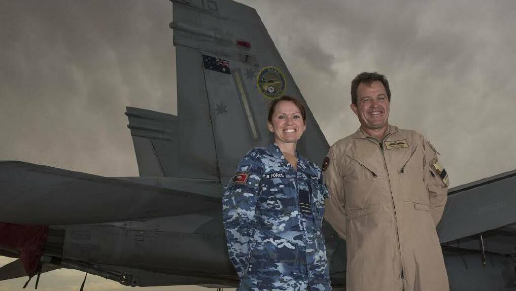  Flight Lieutenant Andrea hateley and Commander Air Task Group, Air Commodore Mike Kitcher stand in front of an F/a-18 Hornet.