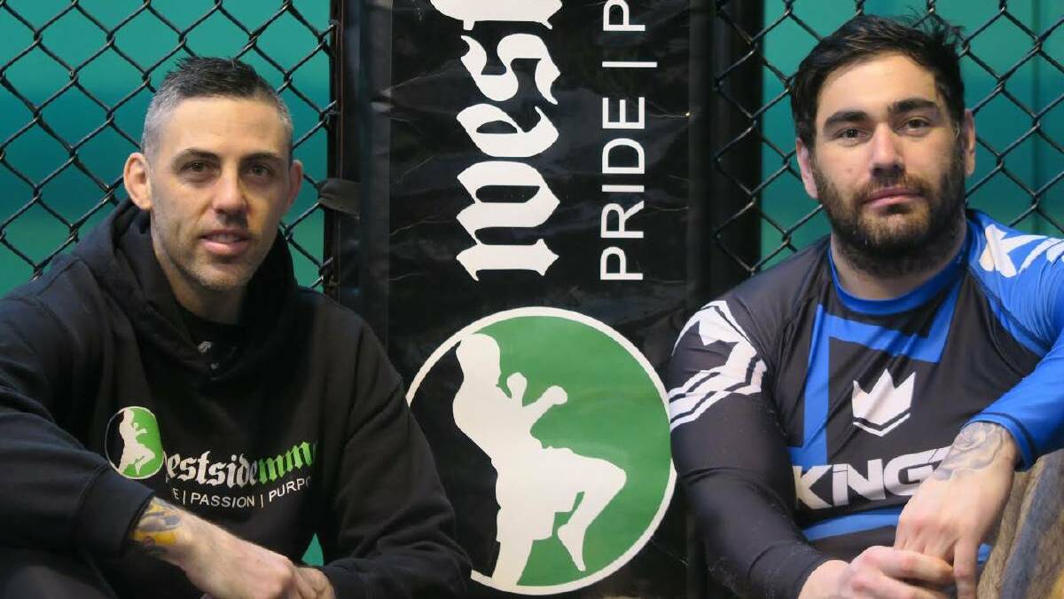 Stuart Grant and Jeremy Joiner sit beside the cage at their training base Westside MMA.