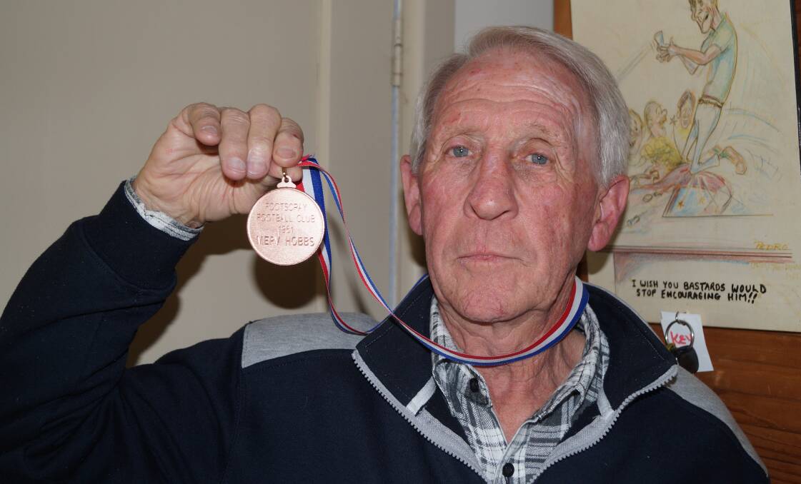 HERO: Former Footscray player Merv Hobbs holds the medal he was awarded for playing in the 1961 grand final against Hawthorn. Picture: Adam Hill
