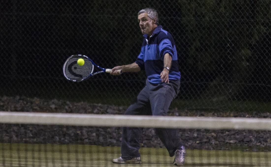 Hard hits: Tom Guthrie in the middle of his game at the Ararat City Tennis Club on Wednesday night, returning to play on the courts after they were washed out last week. Picture: Peter Pickering. 