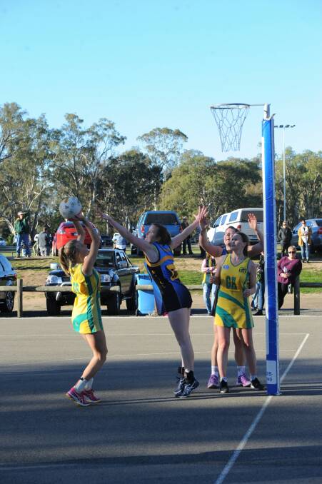 Dimboola's Nicole Polycarpou shoots as Nhill's Emma Hawker defends while Billie-Jo Barber waits under the ring. Picture: SAMANTHA CAMARRI