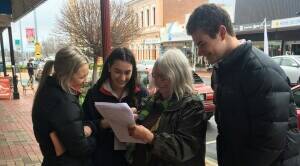 HELPING: Esther Richards, Tayla Dalton and Jack Rutter helping out a community member with the survey the students are conducting. Picture: CONTRIBUTED 