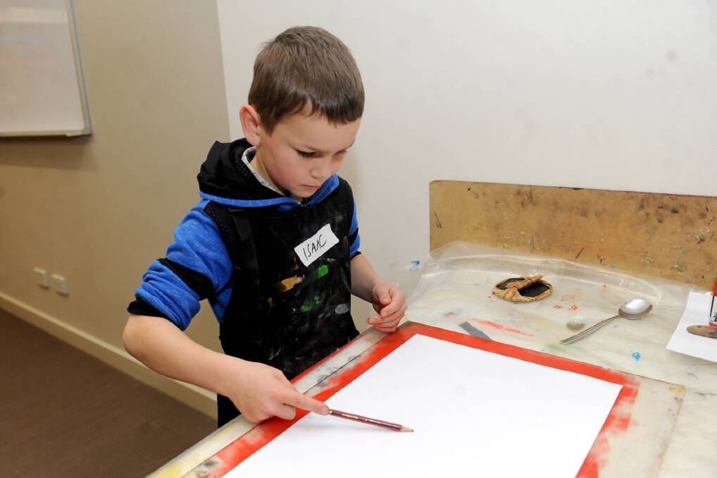 MAKING AND CREATING: Isaac Gregor from Horsham is creating mono prints at the Horsham Town Hall art space during the school holidays. Picture: SAMANTHA CAMARRI