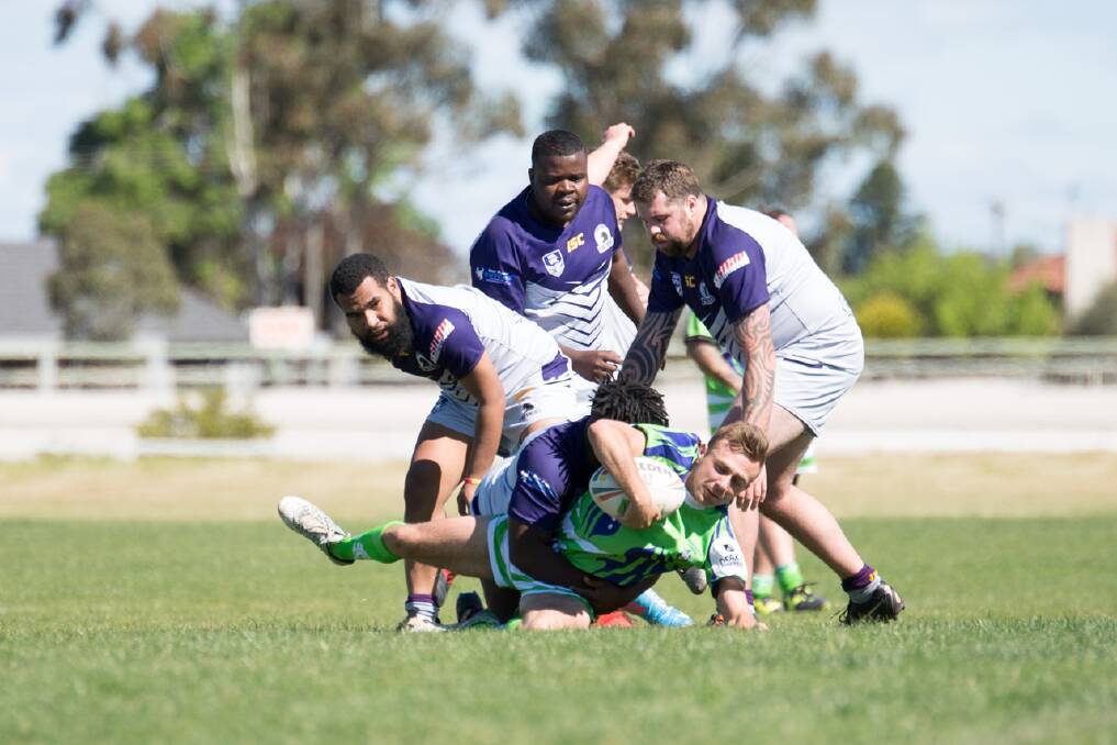 CRUSHING: Eddie Nsanzimana tackles a Warrnambool player with the help of his teammates on Saturday. Picture: SARAH VOISEY