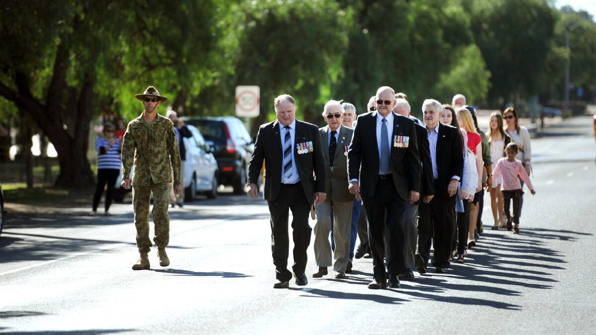 Robert Ellis, front left, leads a march in Main Street, Natimuk, before an Anzac Day service in Natimuk Memorial Hall. Picture: PAUL CARRACHER