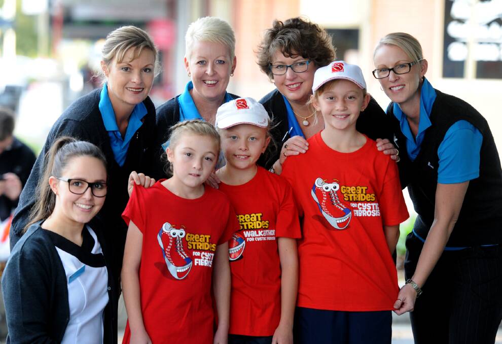 Paige Thompson, front left in red, with sisters Ella and Tahlia and mum Maree, back left, raises awareness of cystic fibrosis with Horsham Amcal staff Lisa Groennou, Pam Capstick and Mel Robertson. Picture: PAUL CARRACHER