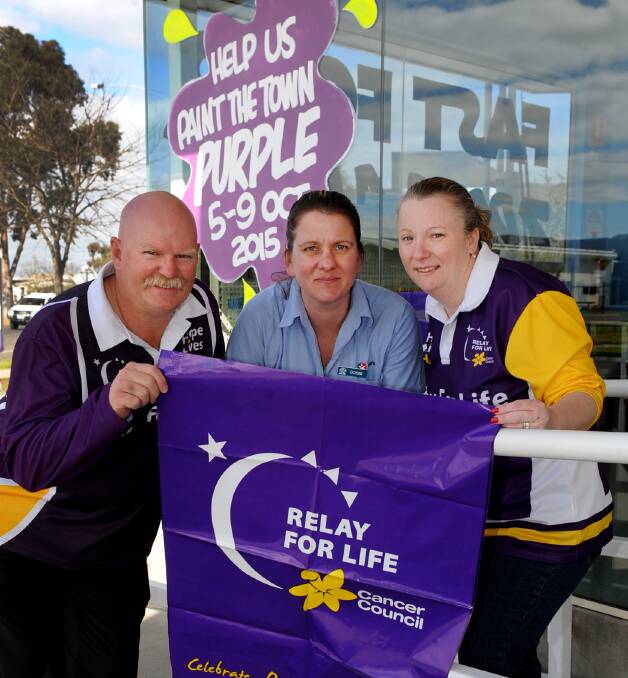 PURPLE HAZE: Paint the Town Purple's Kingsley Dalgleish and Tami Lane, right, prepare for the October event with Caltex Poolside's Bobbi Wade. Picture: SAMANTHA CAMARRI
