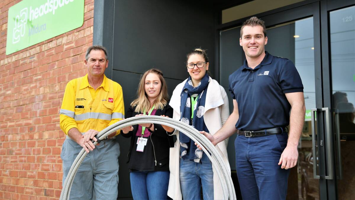 PROUD: Powercor's Robert Sloper and Aaron Hughes (right) with Hannah Cairns and Bridgette Stephenson of headspace Mildura and a roll of the conductor wire. Picture: CONTRIBUTED