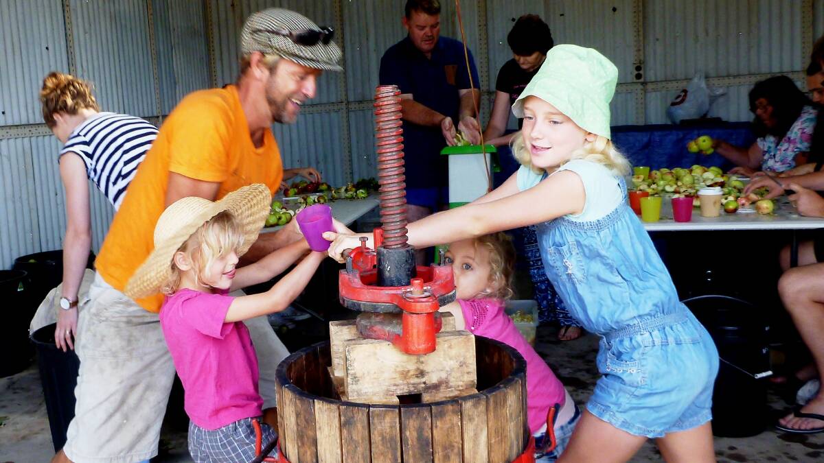 Anthony Schellens with the help of his three daughters Amber, Dusty and Beatrix crushing apples to make apple juice as part of an Horsham Urban Landcare's Apple Crushing Workshop. Picture: CONTRIBUTED