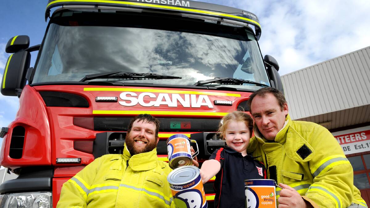 Horsham Fire Brigade Good Friday Appeal co-ordinator and volunteer firefighter Stephen Carman, Horsham Fire Brigade Captain John St Clair and his daughter Bella St Clair, age 4, get ready for the 2017 appeal. Picture: OLIVIA PAGE 