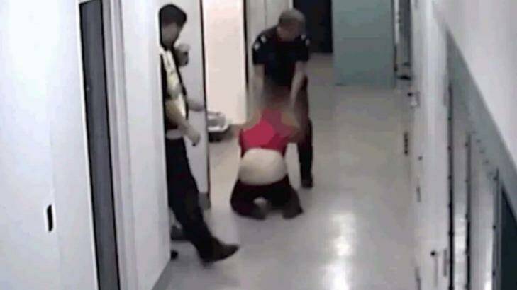 Video still of a woman being dragged by police officers while in custody in Ballarat.