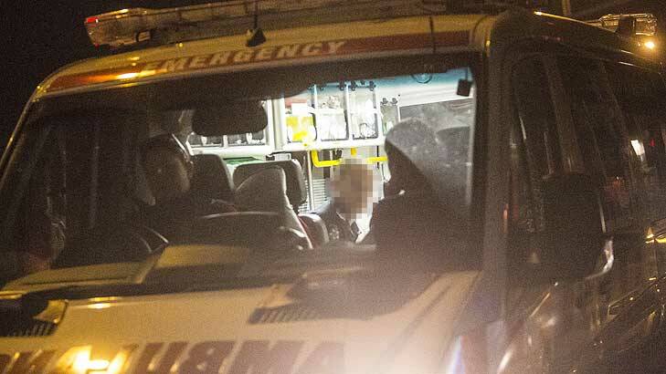 Ambulance officers tend to the injured policeman at Preston on Thursday night. Photo: Craig Sillitoe