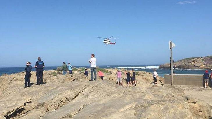 Witnesses look on as an Air Ambulance searches for the men. Photo: Jarrod Woolley/The Standard