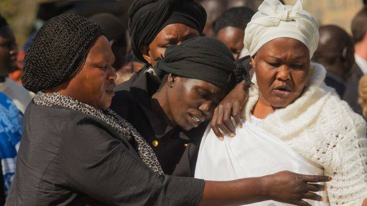 Akon Guode (centre), pictured as she left a funeral service for her children in April, 2015. Photo: Chris Hopkins