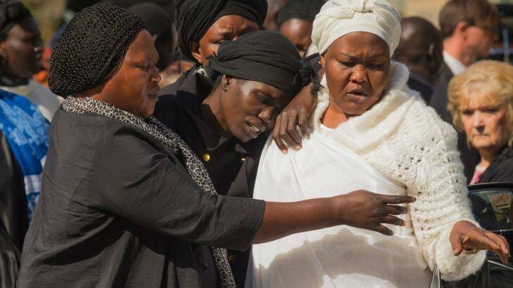 Akon Guode (centre), the mother of three children killed in a lake in Wyndham Vale, makes her way from a funeral service on Saturday. Photo: Chris Hopkins