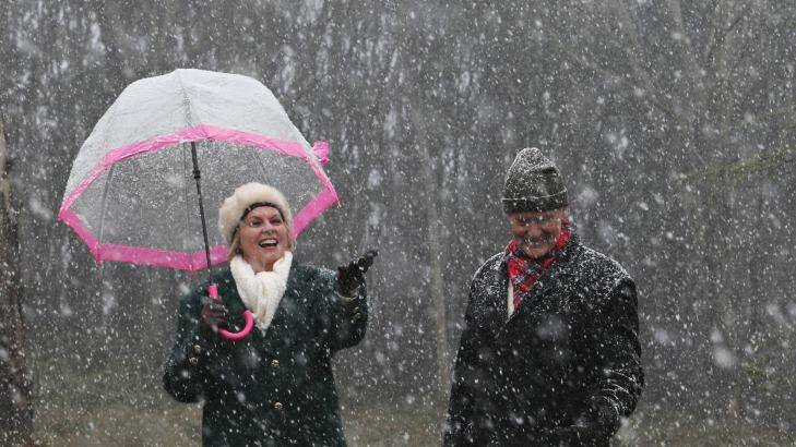 Gloria and Bill Reeves enjoy the snow falling at Mount Macedon last week. More snow is expected on levels as low as 11,000 metres on Thursday. Photo: Paul Rovere