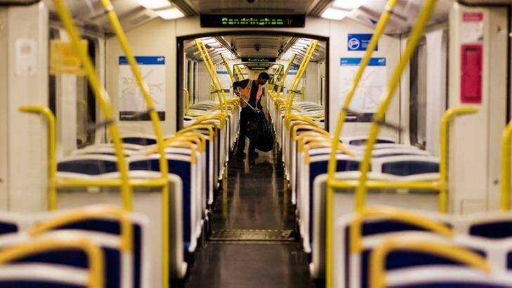 A cleaner clears the mess on a train bound for the city from Sandringham. Photo: Paul Jeffers