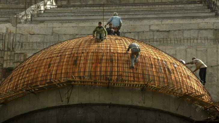 Two workers high above the Arahman Mosque being constructed in Baghdad in 2003. Photo: Jason South