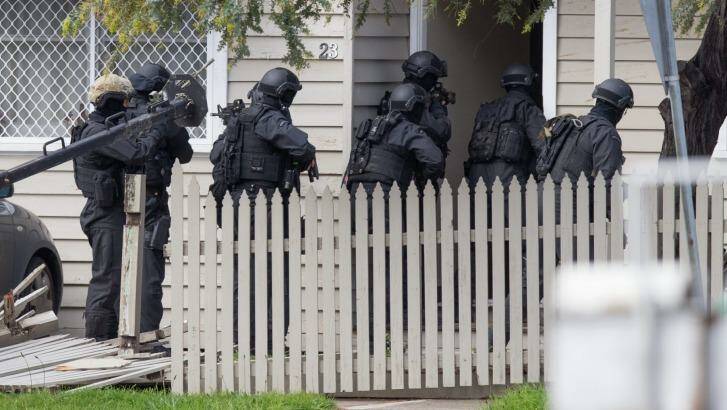 Heavily armed police broke down the door of the house.
 Photo: Jason South