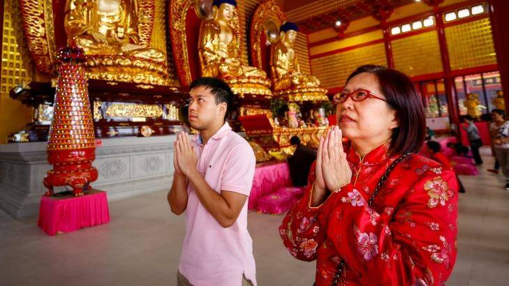 Pody Tung (right) worships on 2016 Lunar New Year at Bright Moon Buddhist temple in Springvale South with her son Jonathan Chang. Photo: Eddie Jim
