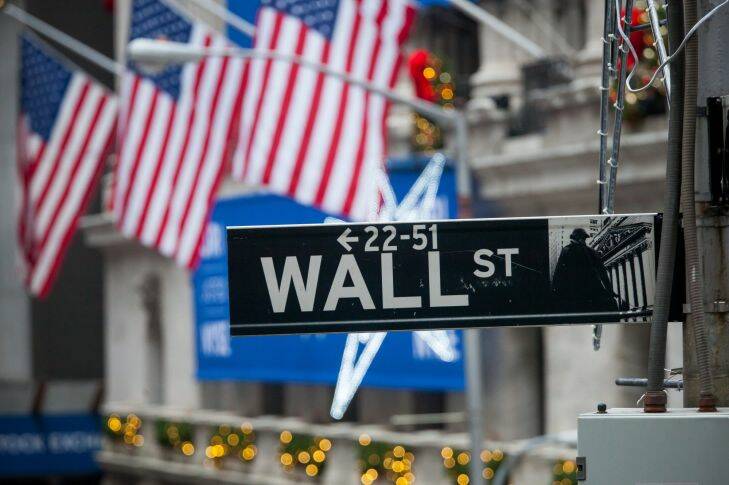 A Wall Street sign is seen in front of the New York Stock Exchange (NYSE) in New York, U.S., on Monday, Dec. 18, 2017. Stocks?? kicked off the penultimate week of the year on a positive note after Republicans reached an agreement on the shape of U.S.?? tax cuts. Photographer: Michael Nagle/Bloomberg