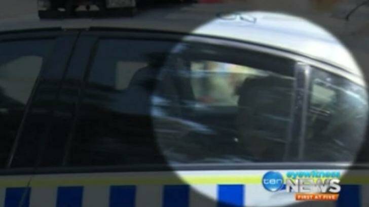 The woman is taken from the scene in a police car.  Photo: Courtesy of Channel Ten