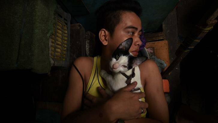 An inmates embraces a kitten as he rests in Quezon city jail, Philippines.  Photo: Kate Geraghty