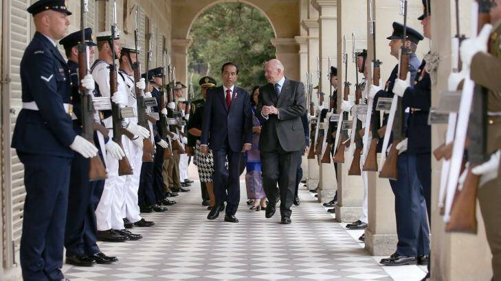 Widodo, center left, walks through an honor guard escorted by Australian Governor-General Sir Peter Cosgrove, center right, as they arrive at Admiralty House in Sydney. Photo: Rick Rycroft