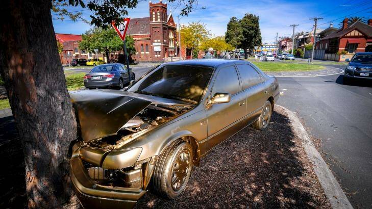 A Toyota Camry dumped on a North Fitzroy median strip has been sprayed all over with gold paint.  Photo: Eddie Jim