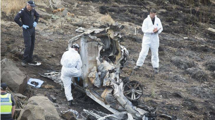 Police investigators pick over the wreckage of the car.  Photo: Simon O'Dwyer