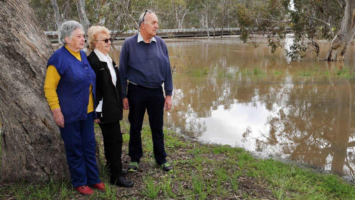 FLOOD RELIEF: Joan Nester, Marj Smith and Rob Smith watch the river at Lower Norton during September's floods. Picture: PAUL CARRACHER 