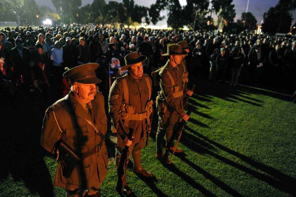 LEST WE FORGET: Ray Buckley, Brett Buckley, Justin Stephens and Brad Stephens stand to attention at Horsham's Anzac Day dawn service on Saturday. The service marked 100 years since the Gallipoli campaign. Picture: PAUL CARRACHER