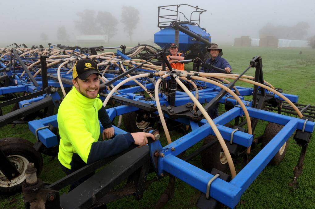 READY TO ROLL: Benedikt Fischer, Kane and Michael Sudholz get the air seeder ready at Michael Sudholz's Natimuk farm on Monday. Pictures: PAUL CARRACHER