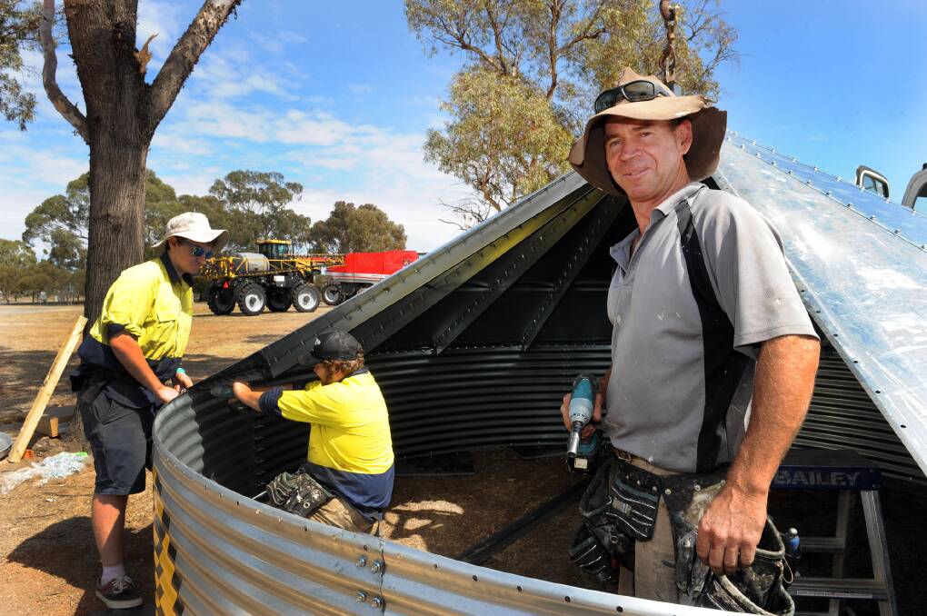 GETTING READY: Cameron Lewis, Michael Paynting and Tim Browell put together a silo at Wimmera Machinery Field Days site. Picture: PAUL CARRACHER