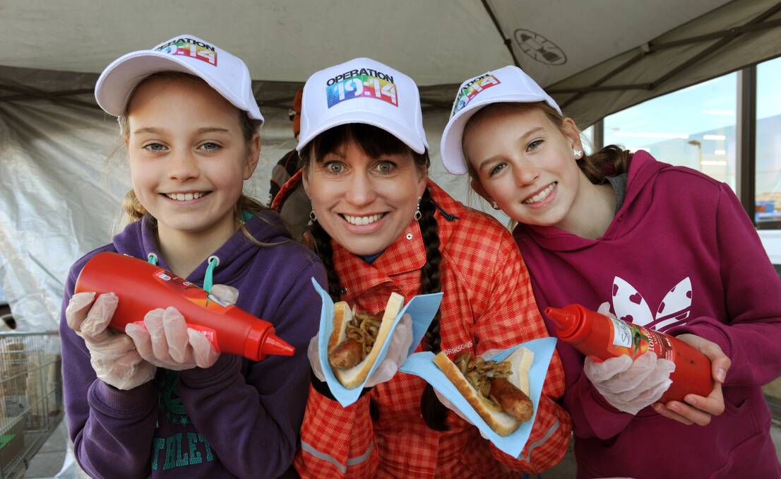 KIND ACT: Yolande Grosser and daughters Yasinta, left, 10, and Katiana, 12, sell 
sausages at Horsham Woolworths to raise money for Operation 19:14 Free Family 
Fun Day. Picture: PAUL CARRACHER