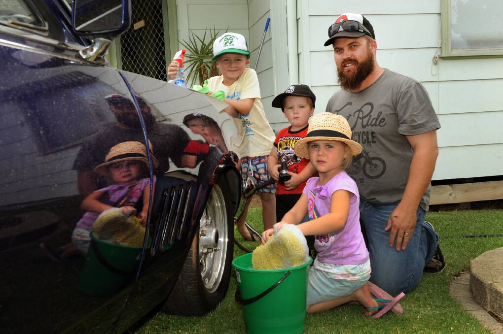 SHOW AND SHINE: Brock, 6, Stevie, 4, Nash, 2, help their dad Simon Clark get his car ready for the Horsham Car and Bike Show at the weekend. Picture: PAUL CARRACHER