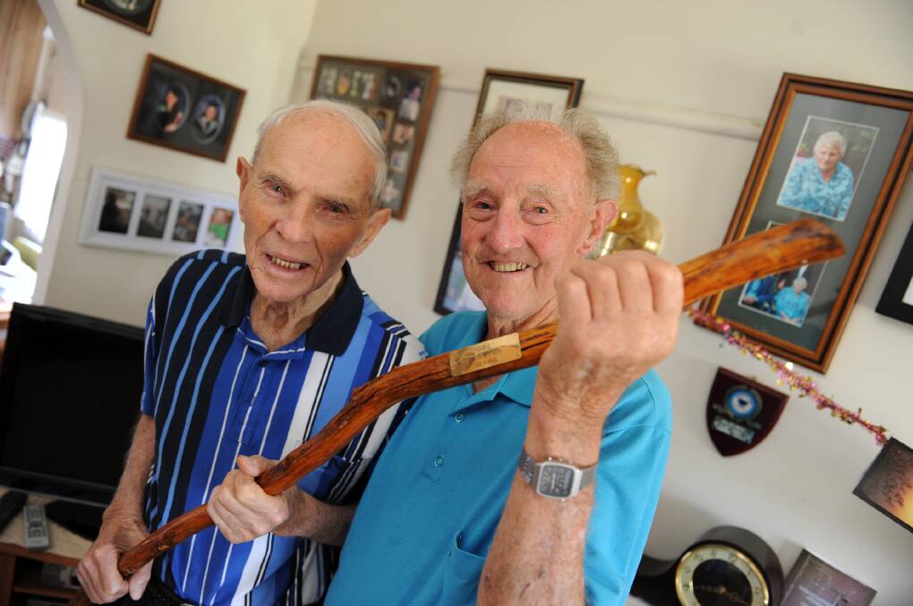 GOING STRONG: George and Jim Price celebrated their 94th birthday together on Friday. They are holding a walking stick given to Jim more than 10 years ago which neither brother has needed. Picture: PAUL CARRACHER