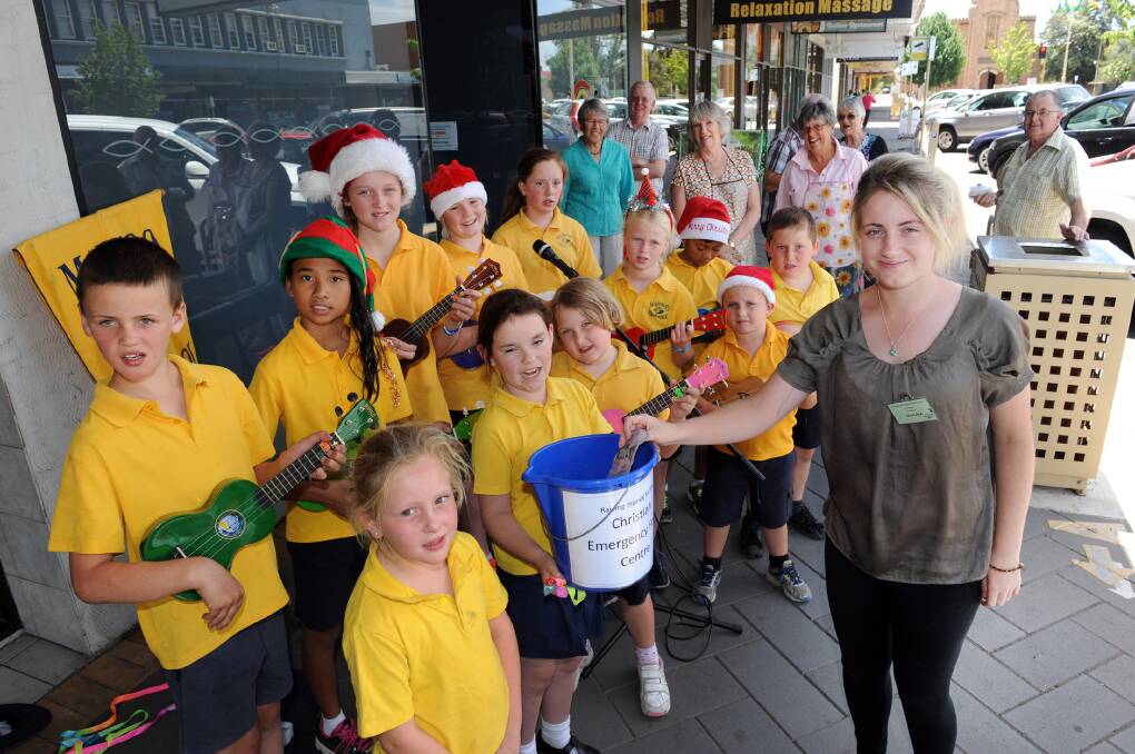 FUNDRAISER: Marnoo Primary School students singing carols outside Horsham's Christian Emergency Food Centre and Shauna Stringer donates money. Picture: PAUL CARRACHER