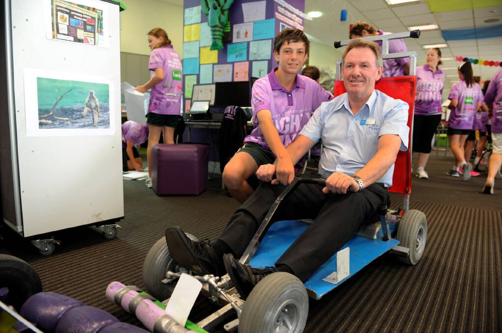 READY TO RACE: Ss Michael and John's Primary School student Aidan O'Connor shows his dad Brian O'Connor one of the school's pushcarts, ready for the RACV Energy Breakthrough Challenge tomorrow. Picture: PAUL CARRACHER