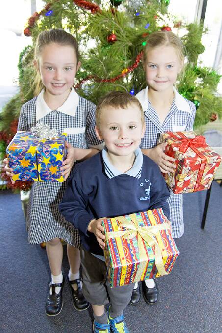 GIVING: Murtoa's Our Ladies Help of Christian Primary School pupils Lili Wilson, Banjo Golder and Riana Warrick share Christmas spirit at the Dunmunkle Giving Tree launch at Murtoa Community Health Centre on Tuesday. Picture: CONTRIBUTED