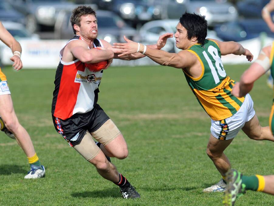 BANNED: Horsham Saint Nathan Clough, left, playing against Dimboola earlier this season. Clough was found guilty of conduct unbecoming after an incident involving Dimboola player Tom Magee and was suspended for six weeks, with four of the weeks suspended until the end of 2016. Picture: PAUL CARRACHER