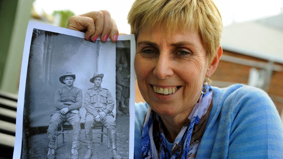 REVISITING THE PAST: Sally Bertram with a photo of her grandfather, Robert Edward Charles, pictured on the right. Picture: PAUL CARRACHER