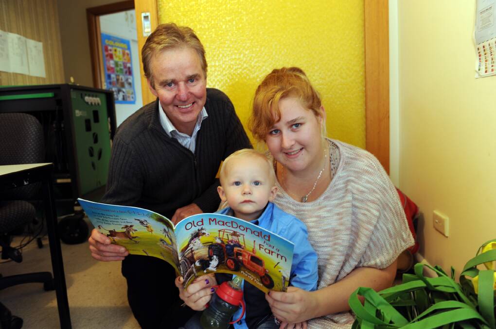 LET’S READ: Wimmera Southern Mallee Local Learning and Employment
Network executive officer Tim Shaw presents a book to young mum Kezra
Hansen and son Tremayne. Picture: PAUL CARRACHER