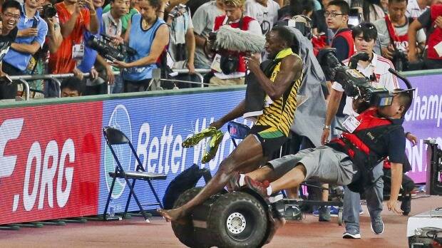 Usian Bolt is hit by a cameraman on a Segway as he celebrates winning the men's 200 metres final at the World Championships in Beijing. Photo: Reuters